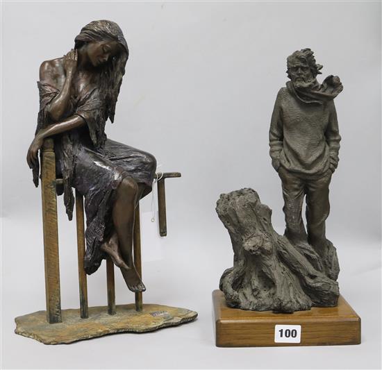 A bronzed statue of a seated lady and another figure